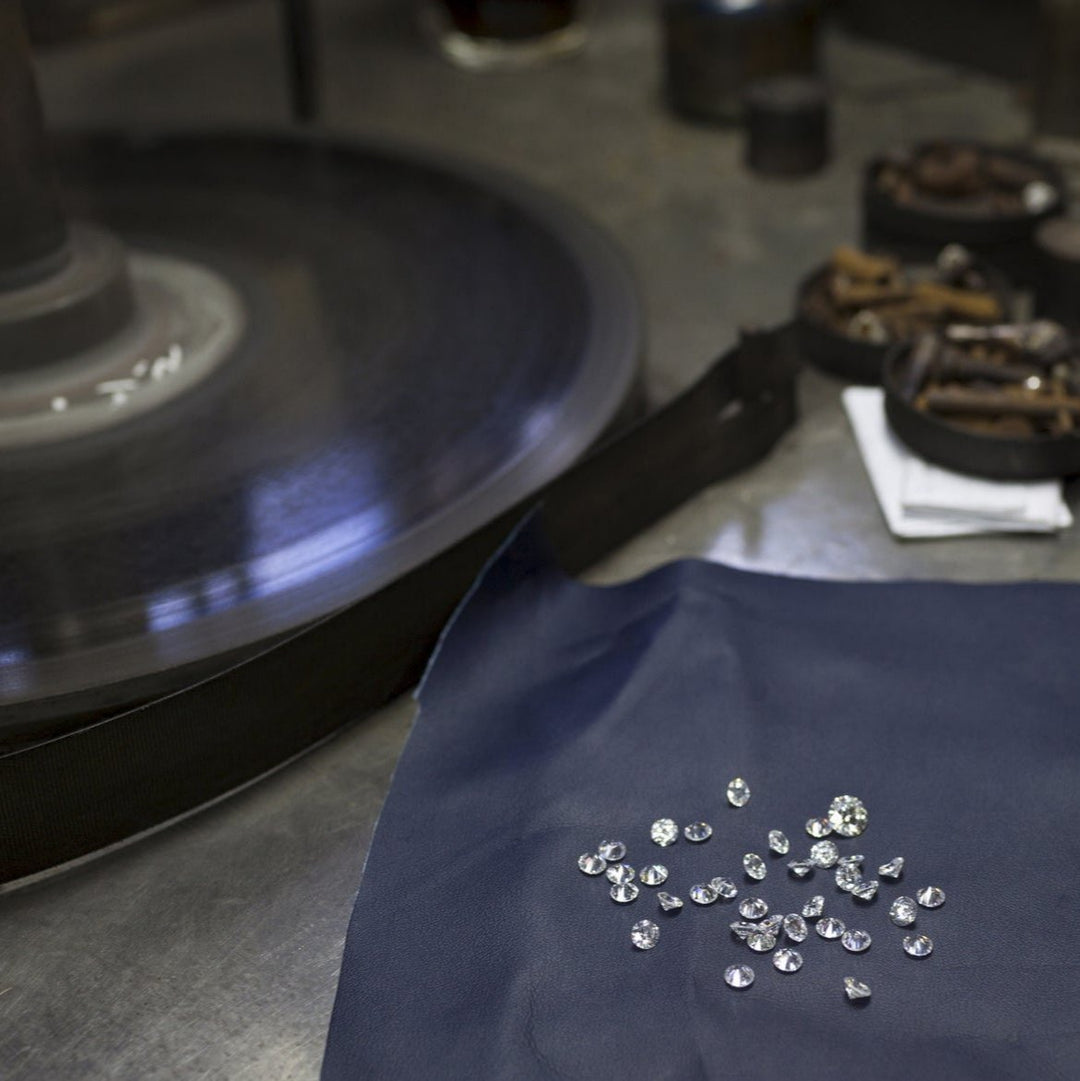 Lose Labordiamanten liegen auf einem Tuch zum sortieren vor einer Diamantschleifmaschine