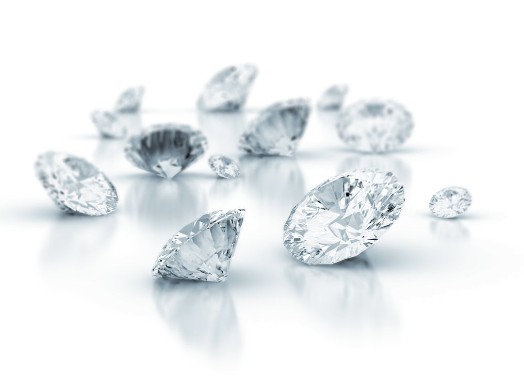 mehrere Labordiamanten liegen auf einer glänzenden Oberfläche